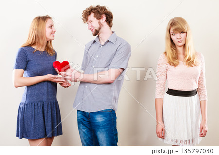 Abandoned woman with enamored couple Abandoned woman with enamored couple 135797030