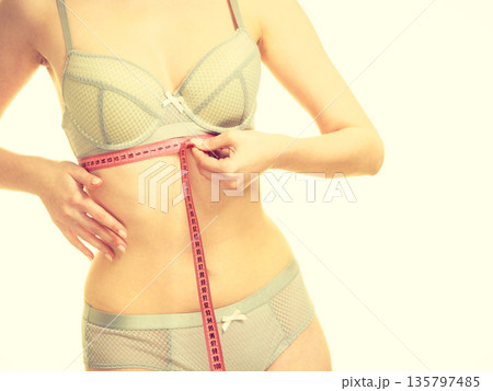 Woman in bra lingerie measuring her chest breasts. Woman in bra lingerie measuring her chest breasts. 135797485