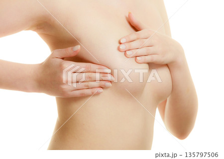 Woman examining her breasts for breast cancer Woman examining her breasts for breast cancer 135797506