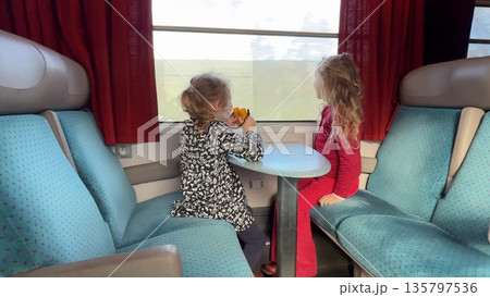 Two girls looking through train window during travel in France 135797536