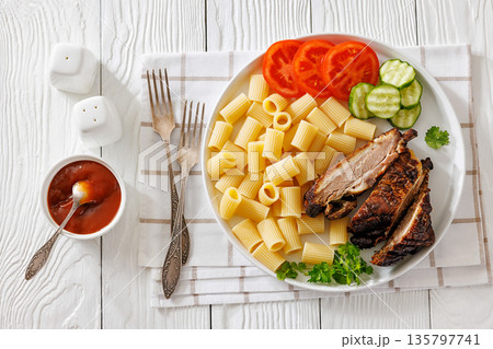 Fried pork ribs with pasta and fresh vegetables 135797741