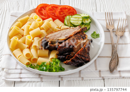 Fried pork ribs with pasta and fresh vegetables 135797744