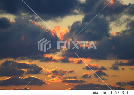 Dramatic red and orange sky and clouds abstract background. Red-orange clouds on sunset sky. Warm weather background. Dramatic red and orange sky and clouds abstract background. Red-orange clouds on sunset sky. Warm weather background. 135798132