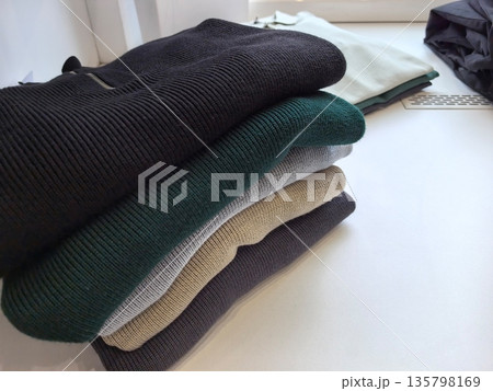 Cozy sweaters stacked neatly on a display for winter fashion shoppers Cozy sweaters stacked neatly on a display for winter fashion shoppers 135798169