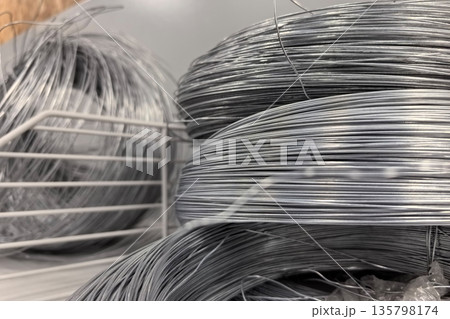 Metal wire coils stacked in an industrial workshop for various uses Metal wire coils stacked in an industrial workshop for various uses 135798174