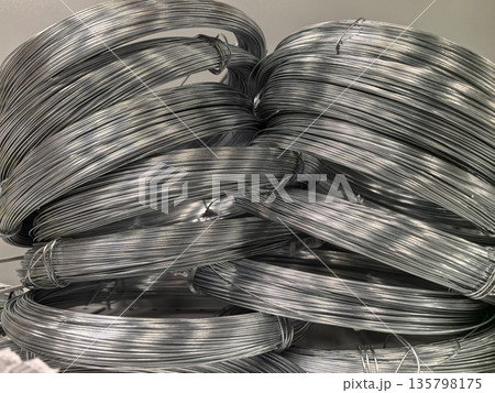 Metal wires coiled and stacked creatively in an industrial setting Metal wires coiled and stacked creatively in an industrial setting 135798175