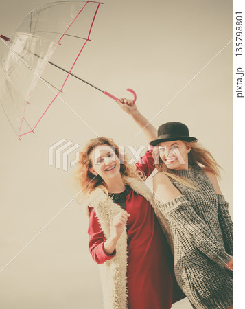 Two fashionable women and umbrella Two fashionable women and umbrella 135798801
