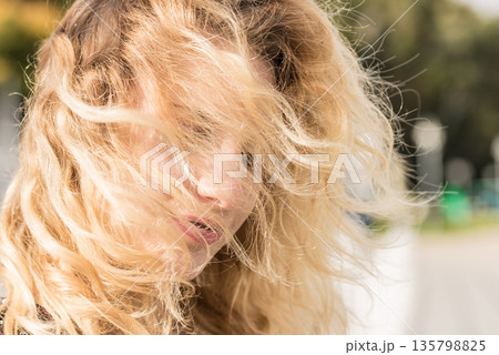 Happy woman outdoor with windblown hair Happy woman outdoor with windblown hair 135798825