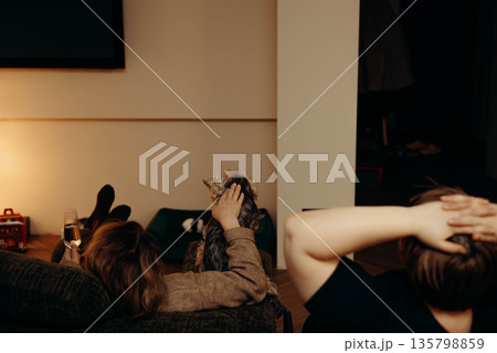 A candid evening at home, relaxation with friends or a partner. Authentic Human trends. Shared, unposed moments, family lifestyle scene. A candid evening at home, relaxation with friends or a partner. Authentic Human trends. Shared, unposed moments, family lifestyle scene. 135798859