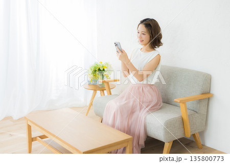 スマホを見る笑顔の女性 スマホを見る笑顔の女性 135800773