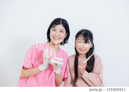 歯科衛生士と小学生の女の子 歯科衛生士と小学生の女の子 135800911