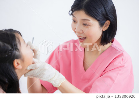 歯科衛生士と小学生の女の子　 135800920