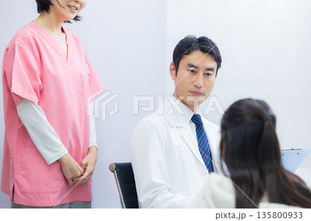 小学生の女の子と看護師と医師 135800933