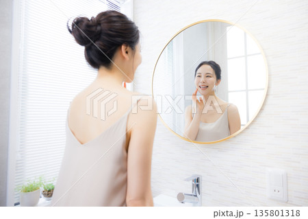 洗面所で鏡を見る若い女性 洗面所で鏡を見る若い女性 135801318