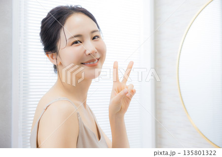 洗面所で鏡を見る若い女性　　 135801322