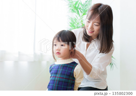 女の子の髪を結ぶお母さん 女の子の髪を結ぶお母さん 135802300