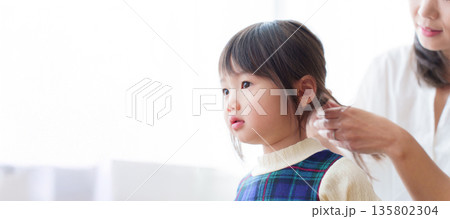 女の子の髪を結ぶお母さん 女の子の髪を結ぶお母さん 135802304