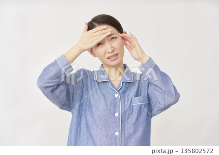 パジャマ姿の女性　発熱と頭痛　白背景 135802572