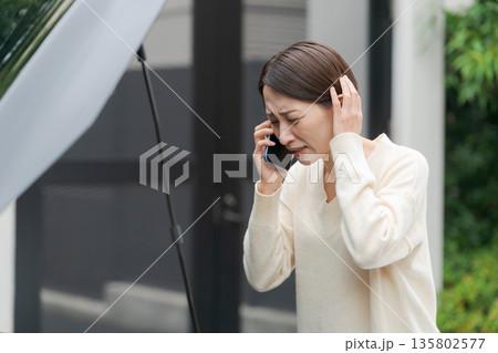 車が故障して電話をする女性 車が故障して電話をする女性 135802577