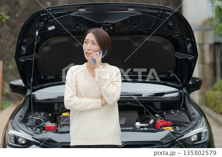 車が故障して電話をする女性 車が故障して電話をする女性 135802579