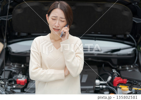 車が故障して電話をする女性 135802581