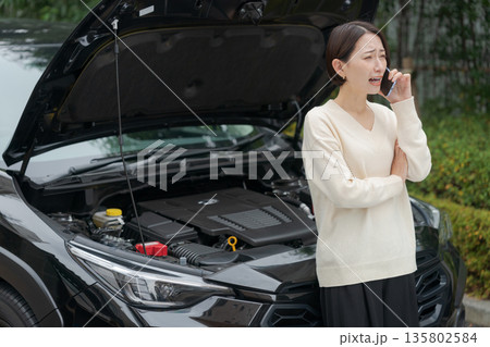 車が故障して電話をする女性 車が故障して電話をする女性 135802584