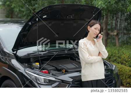 車が故障して電話をする女性 135802585
