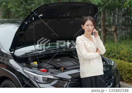 車が故障して電話をする女性 135802586