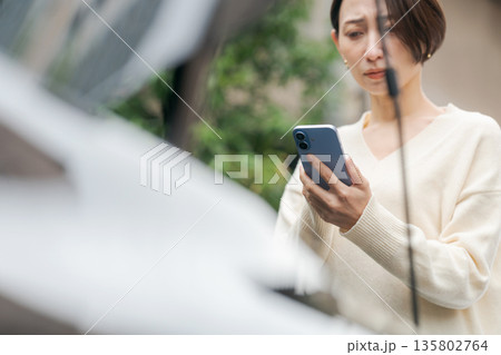 車が故障して電話で連絡をする女性 135802764