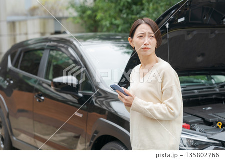 車が故障して電話で連絡をする女性 135802766