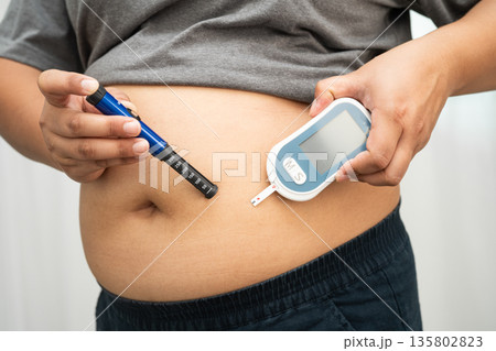 Asian woman injecting herself diabetes injecting insulin in stomach at home. Asian woman injecting herself diabetes injecting insulin in stomach at home. 135802823