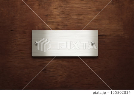 ネジ付き金属プレートと木目背景｜無機質と温もりが調和するリアルモックアップ 135802834