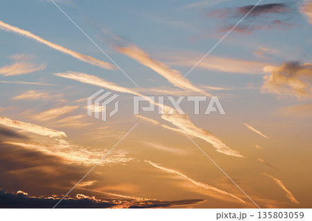 飛行機雲の跡がたくさんある夕暮れの空　b-4 クールカラー 135803059