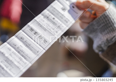 西新井大師 おみくじ中吉を読む手 参拝後の運勢確認 135803245