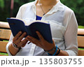 ベンチで本を読む女性 135803755