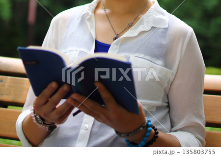 ベンチで本を読む女性 135803755