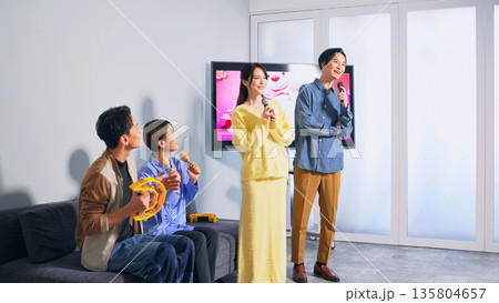カラオケボックスで歌う男女グループ 135804657