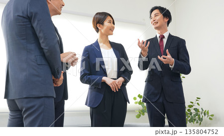 オフィスで立ち話するビジネスパーソンのグループ 135804752