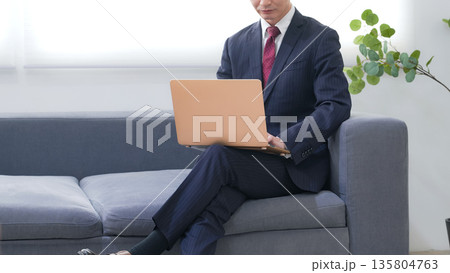 オフィスでノートパソコンを使う男性ビジネスパーソン 135804763
