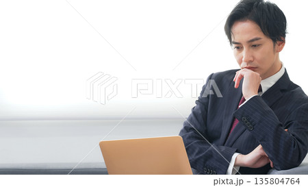 オフィスでノートパソコンを使う男性ビジネスパーソン 135804764