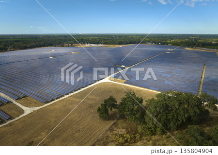 Aerial view of large sustainable electrical power plant with rows of solar photovoltaic panels for producing clean electric energy. Concept of renewable electricity with zero emission 135804904