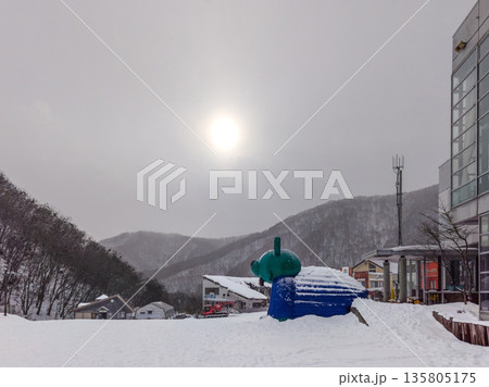 雪が降るスノーパーク尾瀬戸倉の山麓と雲の向こうに透けて見える太陽 (群馬県、片品村) 135805175