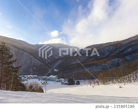 中腹から見下ろすスノーパーク尾瀬戸倉の建物群と日が傾いた冬の景色 (群馬県、片品村) 135805180