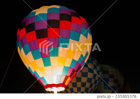 colorful hot air balloons glowing against dark night sky 135805376