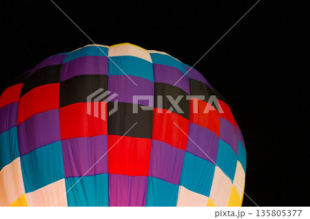 colorful hot air balloons glowing against dark night sky 135805377