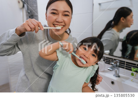 mother teaching girl child to brushing teeth in bathroom mother teaching girl child to brushing teeth in bathroom 135805530