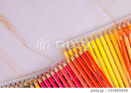 Set of colored pencils is spread out on smooth surface, showing variety of colors 135805649