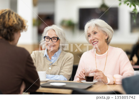Large friendly family gathered at table to have meeting in restaurant 135805742