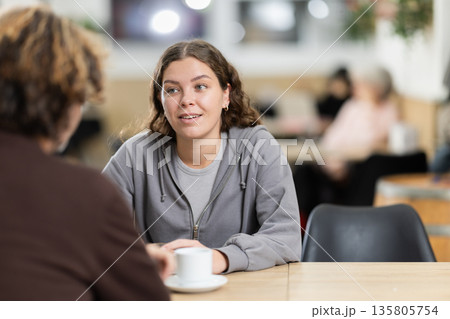 Girl in cafe sits near guy companion, work or romantic meeting dating Girl in cafe sits near guy companion, work or romantic meeting dating 135805754