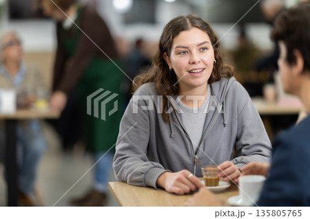 Girl in cafe sits near guy companion, work or romantic meeting dating Girl in cafe sits near guy companion, work or romantic meeting dating 135805765